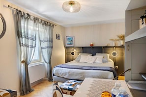 Une chambre bien rangée, avec un lit, des tables de chevet, un bureau et une chaise.