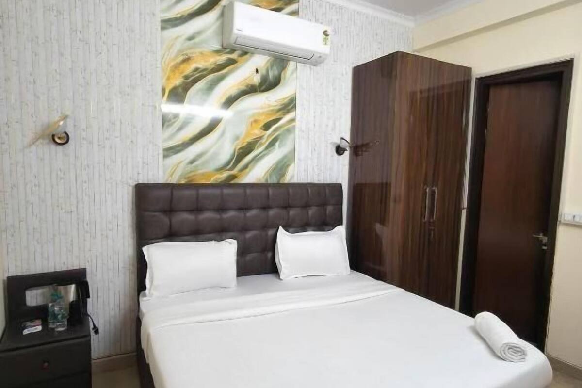 Un dormitorio con cama, ventilador de techo, armario y mesita de noche.