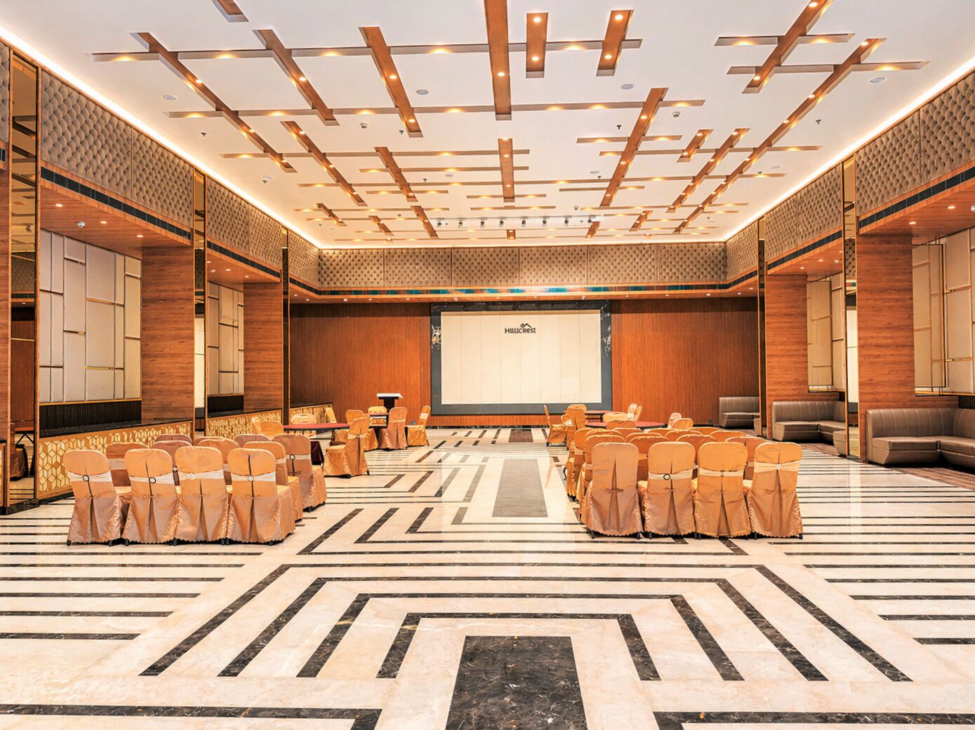 A conference room with a large screen, wooden paneling, and a patterned floor.