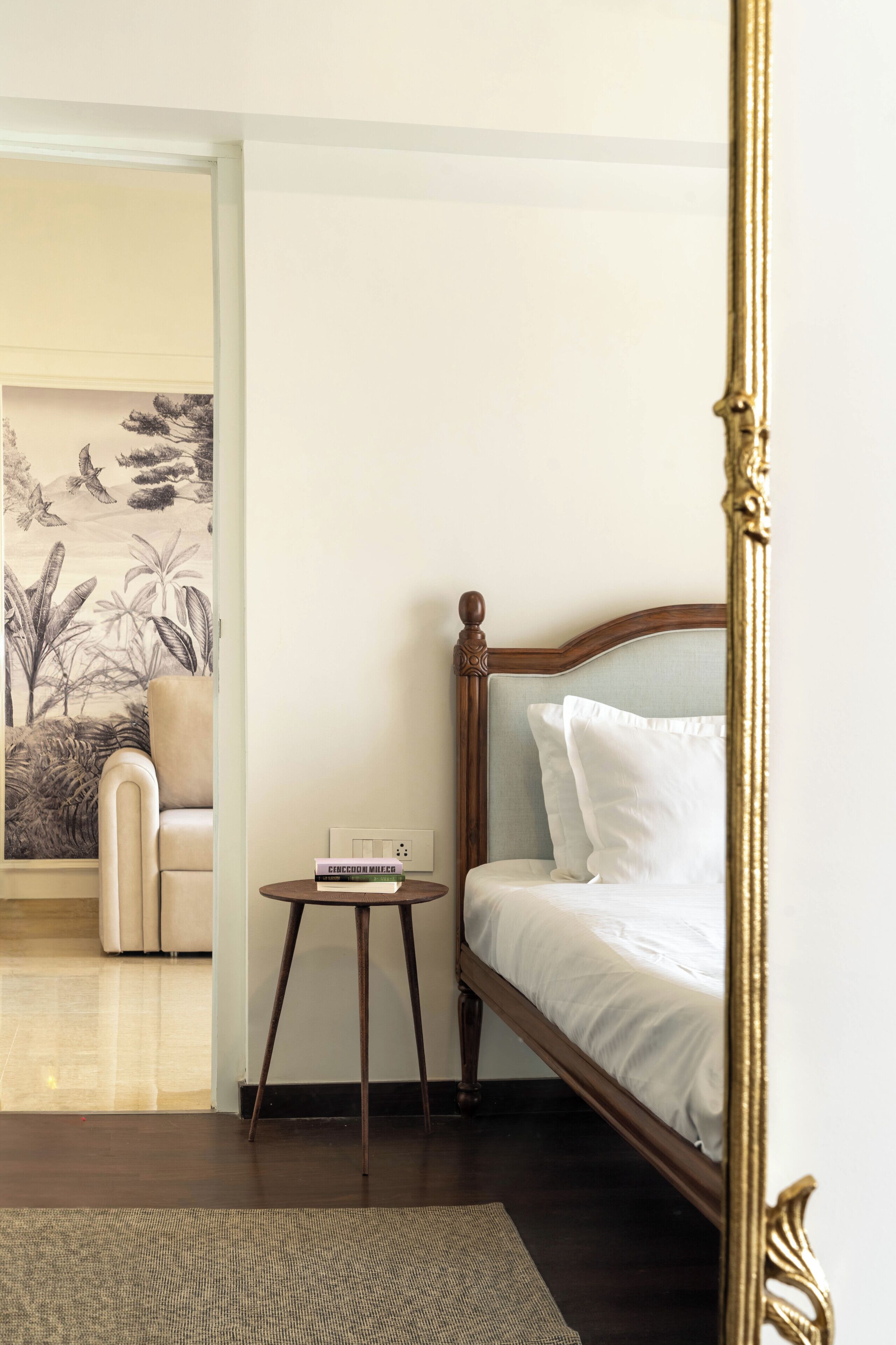 Een slaapkamer met een bed, een klein nachtkastje, een stoel en een wanddecoratie.