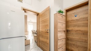 Eine Küche mit einem weißen Kühlschrank, Holzschränken und einer Pflanze darauf.