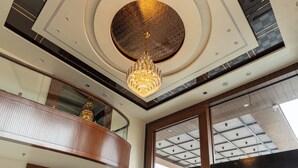 A hotel lobby with a geometric patterned floor, a grand chandelier, and a reception desk. - Innara - A Boutique Luxury Hotel (Jaipur)