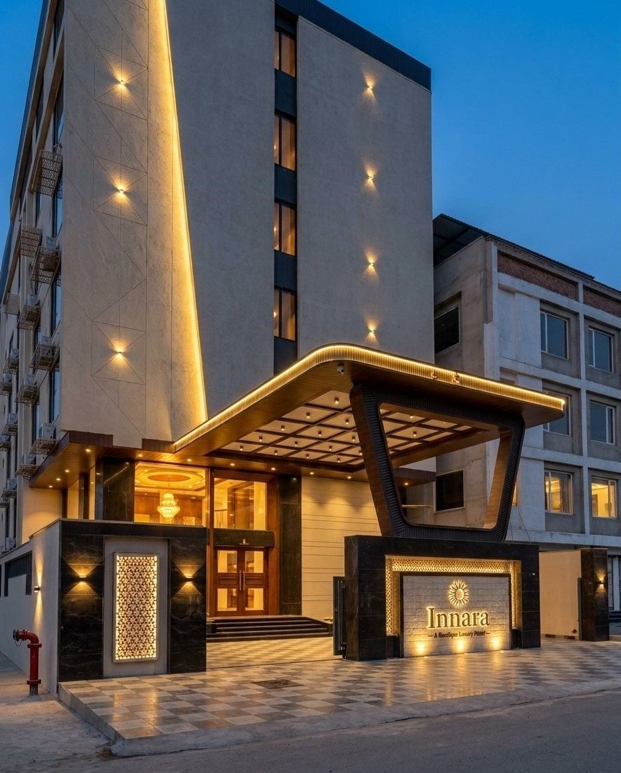 A hotel entrance with a modern design, featuring a prominent entrance canopy and illuminated signage.