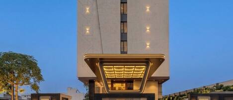 Una entrada de hotel moderna con un llamativo letrero que dice 'Innara Boutique Hotel'.