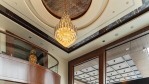 A spacious lobby with a geometric patterned floor, a chandelier, and a reception desk. - Innara - A Boutique Luxury Hotel (Jaipur)