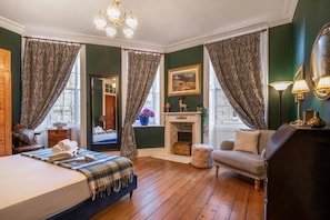 A room with a bed, a sofa, a fireplace, and curtains. - Iconic Royal Mile Residence. Entire rental unit in Edinburgh, United Kingdom (Edinburgh)