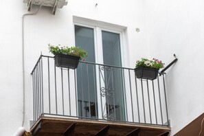 A balcony with metal railings and two flower planters. - Room 'Donna Letizia - Triple' with Balcony, Wi-Fi and Air Conditioning (Agrigento)
