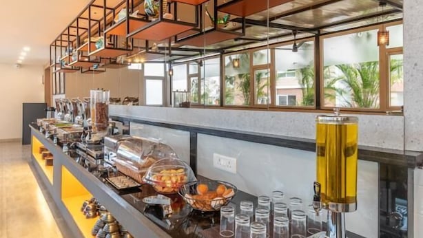 En buffet med diverse mad og en kaffemaskine.