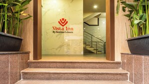 En hotelindgang med et skilt, der siger 'Vista Inn By Bestinn Leisure', en marmorvæg og en trappe, der fører ind.