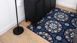 A room with a black cabinet, a flat-screen TV on top, a floor lamp, and a patterned rug. - Downtown Detroit Swanky Suite (Detroit)