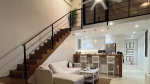 A modern living room with a staircase, a kitchen area, and a dining space. - Cozy studio at Portillo, Las Terrenas (Las Terrenas. El Portillo Residences.)