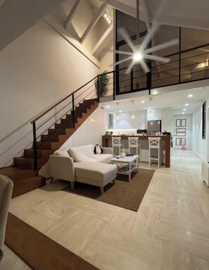 A modern living room with a staircase, a kitchen area, and a dining space. - Cozy studio at Portillo, Las Terrenas (Las Terrenas. El Portillo Residences.)