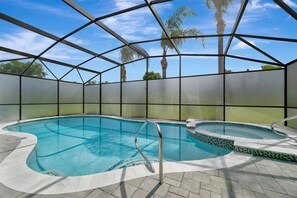 Une piscine intérieure dotée d’un toit en verre, d’un revêtement de sol en carrelage et d’une échelle en métal.