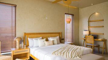 A bedroom with a bed, bedside tables, a desk, and a chair.