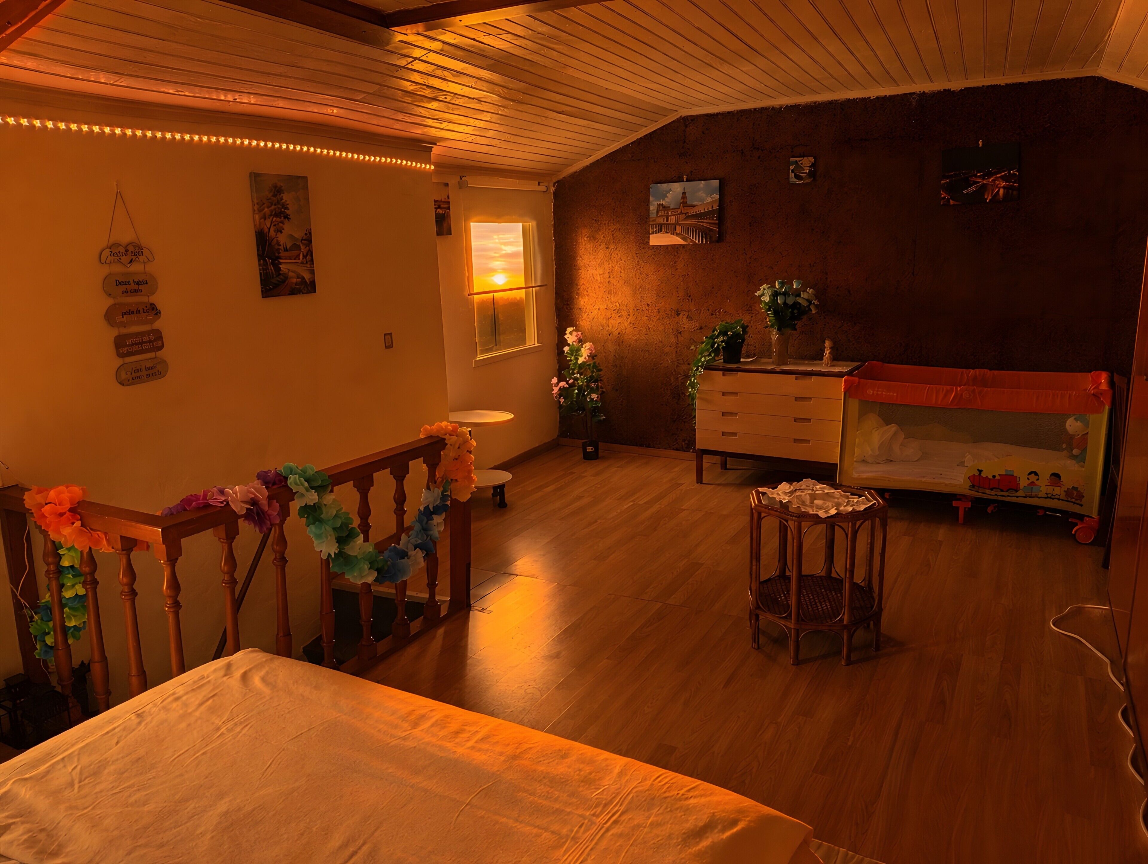 Une pièce chaleureuse avec un plancher en bois, un lit, une commode et une fenêtre donnant sur un beau paysage.