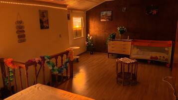 Une pièce chaleureuse avec un plancher en bois, un lit, une commode et une fenêtre donnant sur un beau paysage.