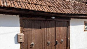 Il s’agit d’un bâtiment traditionnel, doté d’un toit recouvert de tuiles, d’une porte double en bois avec une boîte aux lettres et d’une petite fenêtre.