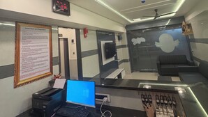 A hotel reception desk with a laptop, a phone, a calculator, and a red notebook labeled 'HOTEL BOOK.' - Hotel Kalp Rooms (Vyara)
