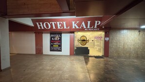 A hotel entrance with a sign reading 'HOTEL KALP,' a welcome sign, and a directory for rooms and address. - Hotel Kalp Rooms (Vyara)