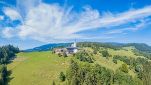 A rural landscape with a church and surrounding fields. - Gasthof Gutmann (Eberstein)