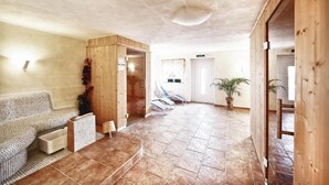 A spacious room with a tiled floor, a wooden bench, a sofa, and a door leading to another area. - Gasthof Gutmann (Eberstein)