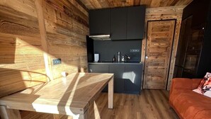 Una cocina funcional con electrodomésticos modernos, una mesa de comedor y un sofá.