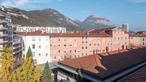 Un immeuble à plusieurs étages, doté d’un toit recouvert de tuiles rouges, de murs blancs et d’un balcon.