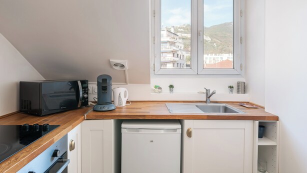 Une cuisine équipée d’un four à micro-ondes, d’une machine à café et d’un lave-vaisselle.