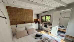 Un dormitorio con cama, cabecera de madera, escritorio y ventana.