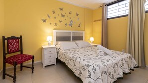 A bedroom with a bed, bedside tables, a chair, and butterfly wall decals. - Summerland 5 - 1 bedroom with terrace and pool view (Los Cristianos)