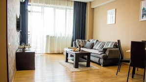 Una sala de estar con un sofá, una mesa de centro y un televisor sobre un mueble.