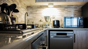 Una cocina moderna con electrodomésticos de acero inoxidable, cafetera y microondas.