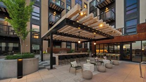 Ein Außenbereich mit Holz-Pergola, Bar und moderner Möbel.