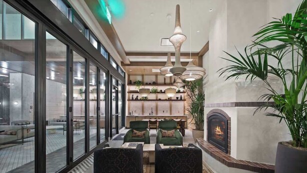 Un intérieur moderne comprenant un coin repas, une cheminée et une grande fenêtre.