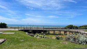A coastal walkway with a bridge, grassy areas, and a view of the sea. - Beachfront Apartment @ Apollo (Apollo Bay)
