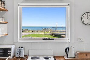 Eine Küche mit Meerblick, einem Toaster, einem Wasserkocher und einer Wanduhr.