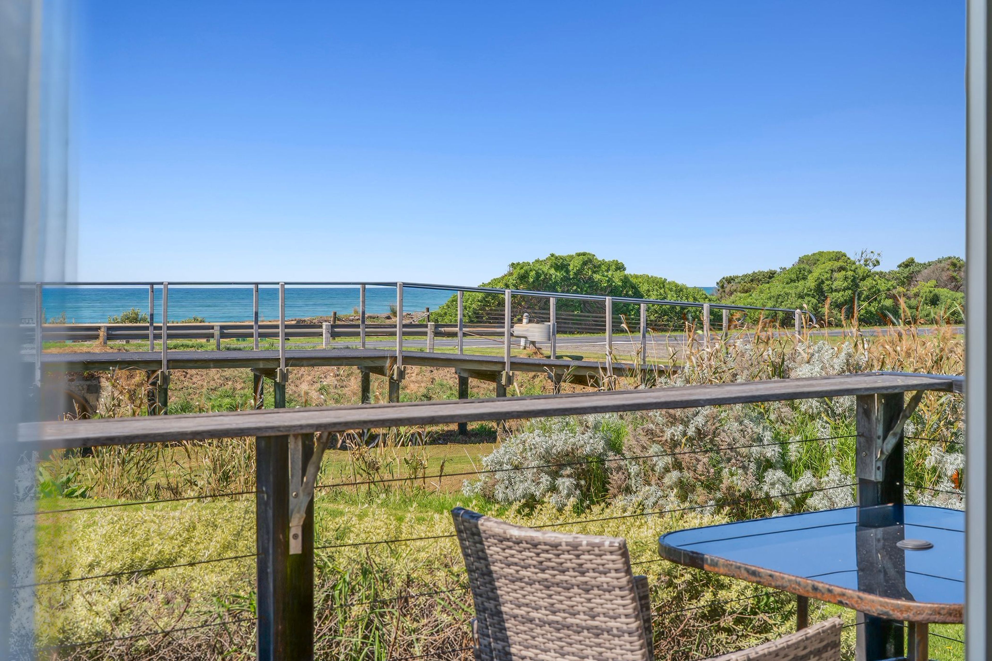 Un balcon avec vue sur la mer, une table et des chaises.