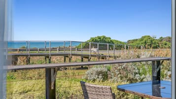 Un balcon avec vue sur la mer, une table et des chaises.