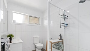 Un baño moderno con inodoro, ducha y lavamanos.