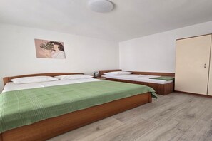 A bedroom with two beds, a wardrobe, a bedside table, and a wall-mounted artwork. - Coastal Bungalow for 5 in Zaton (Zaton)