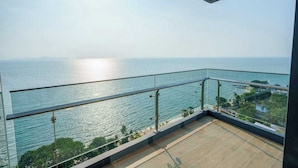A balcony with a view of the sea and distant mountains. - Luxury 2BR Sea View Apartment with Private Lift and Free Parking (Pattaya)