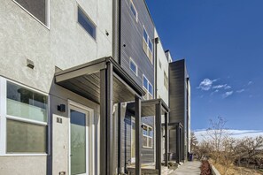 A multi-story building with a covered outdoor area, large windows, and a clear sky. - Remote Work Friendly-Fast Wifi|3 min to Light Rail (Denver)