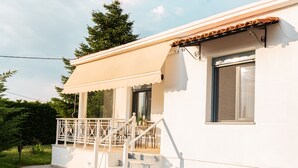 A white building with a balcony, steps, and a window with curtains. - Hebe's house | Cozy Village Escape Near Tripoli (Stadio)