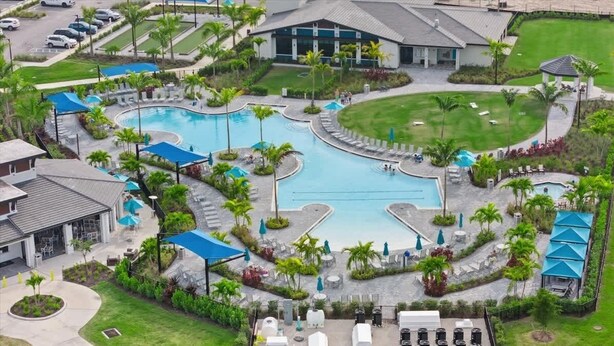 Un complexe hôtelier doté d’une grande piscine centrale, de plusieurs piscines plus petites et d’un vaste espace vert bien entretenu.
