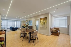 A modern living space with a dining area, a sofa, and a painting on the wall. - ELIZ APARTMENT (Osogbo)