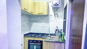 A compact kitchen with a gas stove, oven, and sink. - ELIZ APARTMENT (Osogbo)