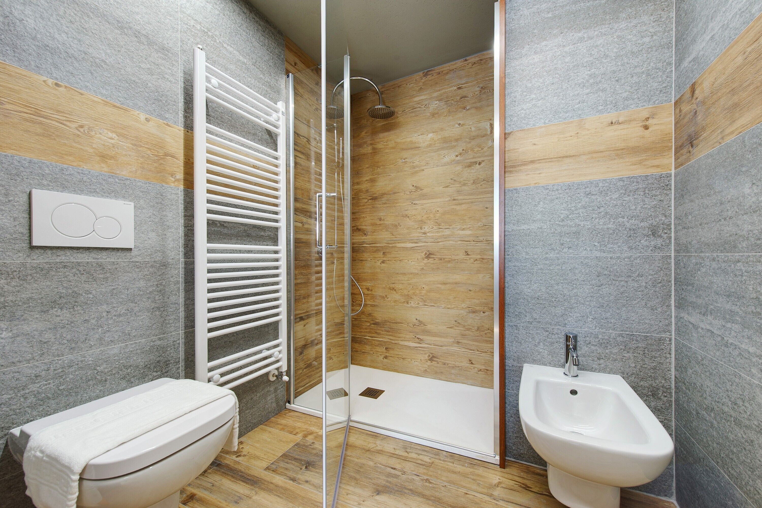 Une salle de bain moderne équipée d’une douche, de toilettes et d’un bidet.