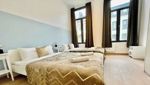 Une chambre d’hôtel avec un lit, des tables de chevet, une fenêtre et un radiateur.
