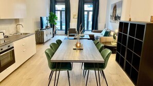 A modern kitchen with a dining area, a sofa, and a TV. - Antwerp Retreat with Kosher Kitchen (Antwerpen)