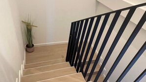 Een trap met houten treden en zwarte leuningen.